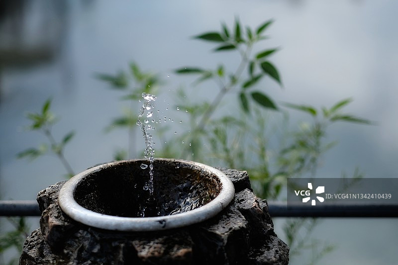 圆形石制户外喷泉，水从底部涌出图片素材