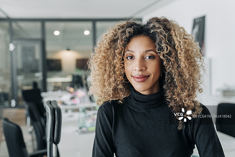 工作中留着卷发的年轻女商人肖像图片素材