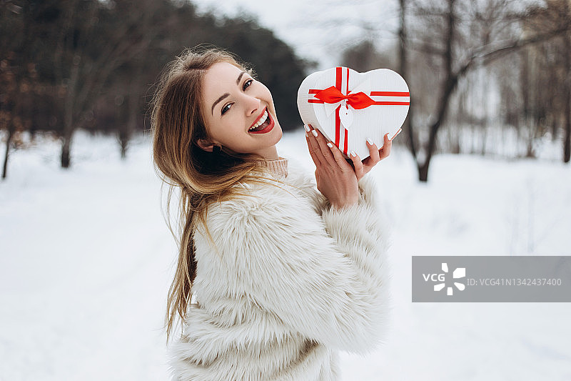 拿着白色心形盒子的年轻女子图片素材