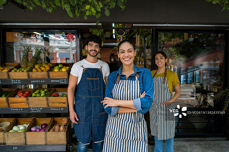快乐的女店主与员工在超市工作图片素材