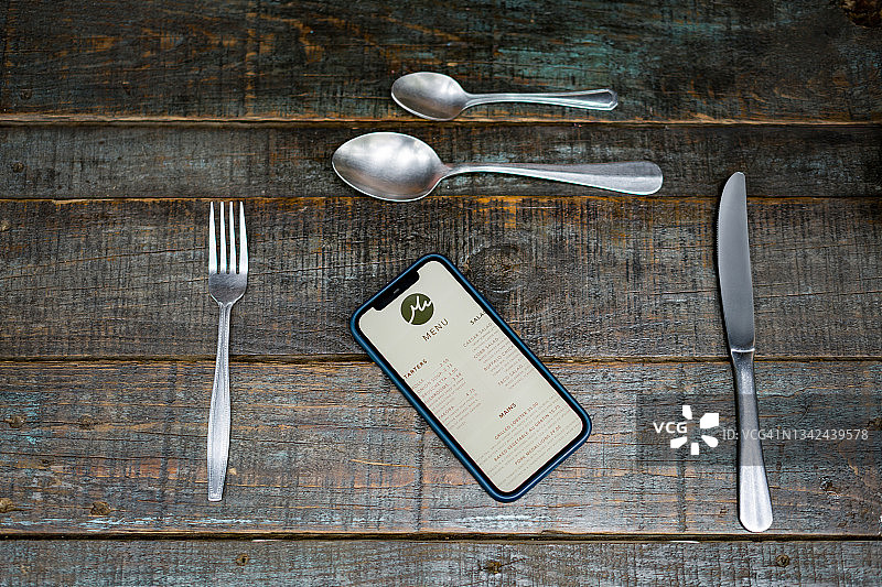 餐厅桌面上显示菜单的手机图片素材