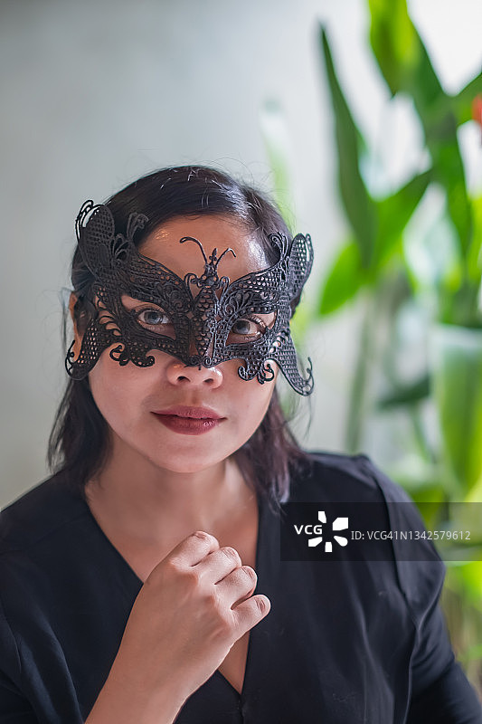 戴黑色化装舞会面具的印尼女子图片素材