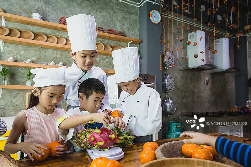 一群亚洲儿童在学校厨房准备水果冰沙图片素材