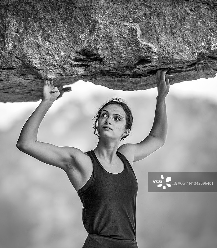女攀岩者抓握悬崖岩壁图片素材