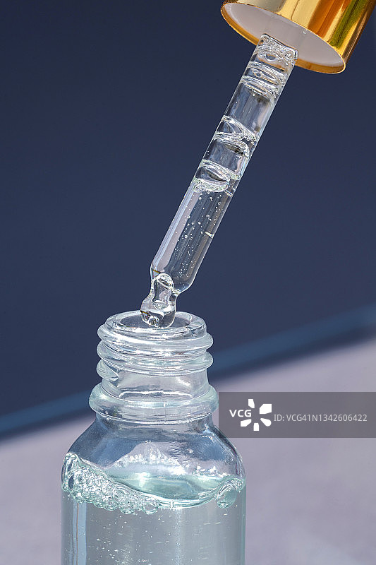 灰色背景玻璃瓶滴管精华液特写图片素材