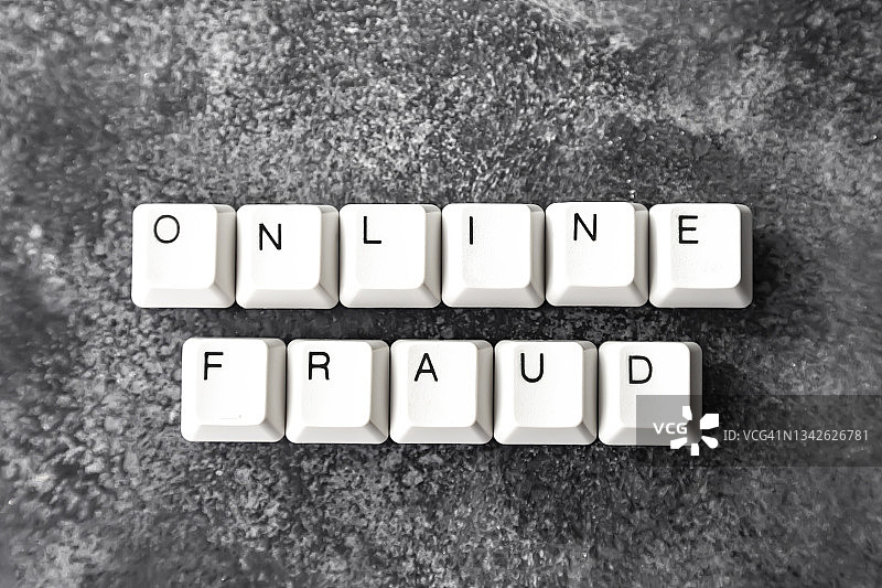 黑色背景上拼出“ONLINE FRAUD”的电脑键盘图片素材