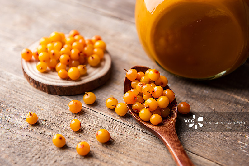 玻璃罐中新鲜成熟的橙色沙棘浆果维生素汁图片素材