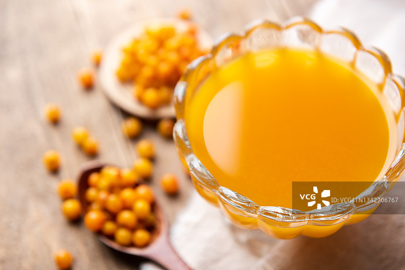 玻璃罐中新鲜成熟的橙色沙棘浆果维生素汁图片素材