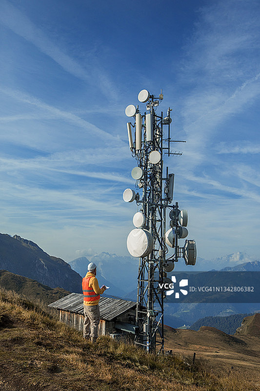 在通信铁塔山地工作的男性工程师图片素材