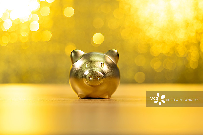 闪亮金色背景上的存钱罐图片素材