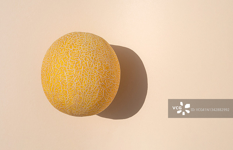 米色背景上的黄色圆形多汁成熟甜瓜，留白图片素材
