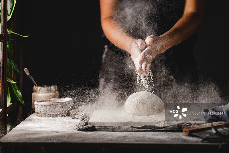 女子在大理石台面上揉面包面团的特写图片素材