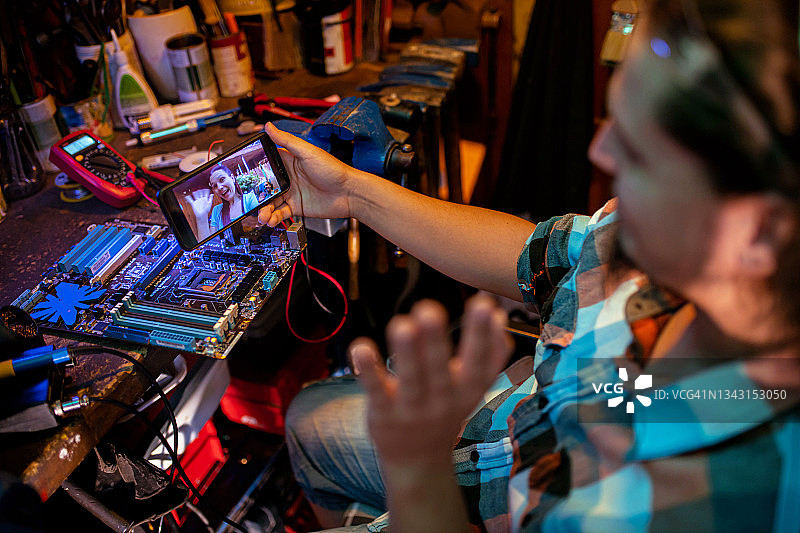 工作休息期间，维护工程师在与家人的视频通话中挥手图片素材