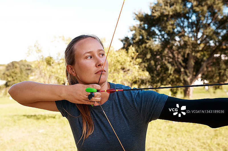 在射箭场练习射箭的年轻女子照片图片素材