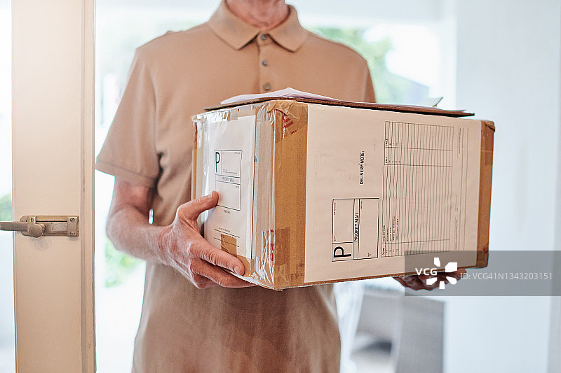一位男性快递员上门送货的局部照片图片素材