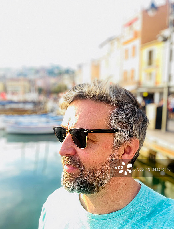 日落时分，在法国卡西斯海滨村庄的络腮胡男人-库存照片图片素材