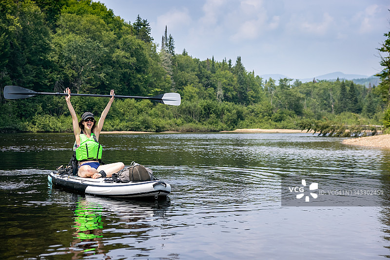 夏季女子在河上划桨板和皮划艇图片素材