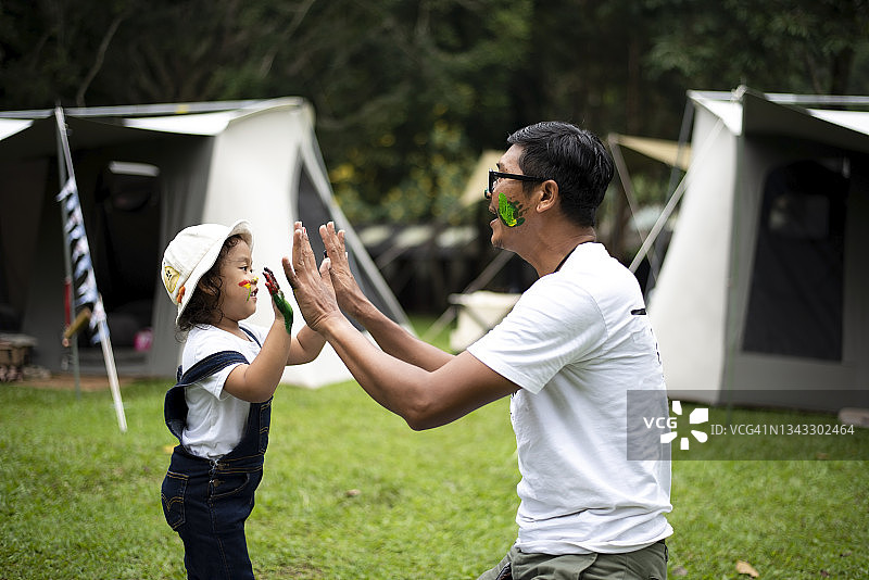 叔叔和侄子在露营地玩涂色游戏图片素材