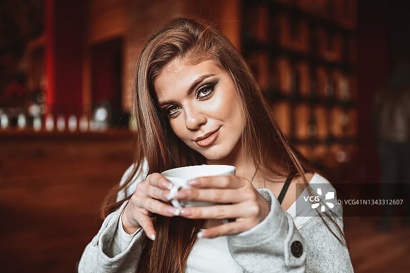 在酒吧享用下午茶的漂亮金发女子图片素材