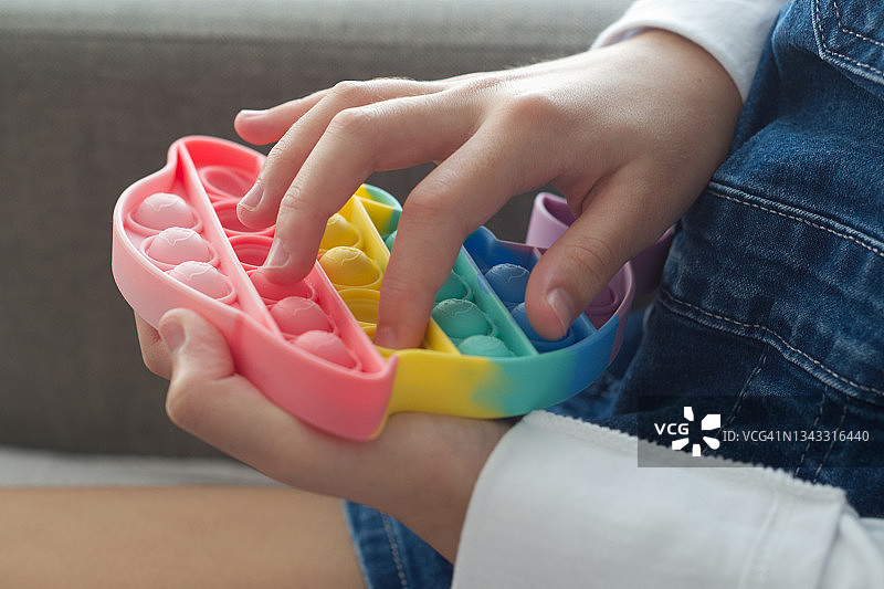 小孩玩海豚形状的指尖玩具——横版图片素材