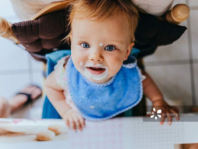 快乐的女宝宝吃完酸奶后抬头图片素材