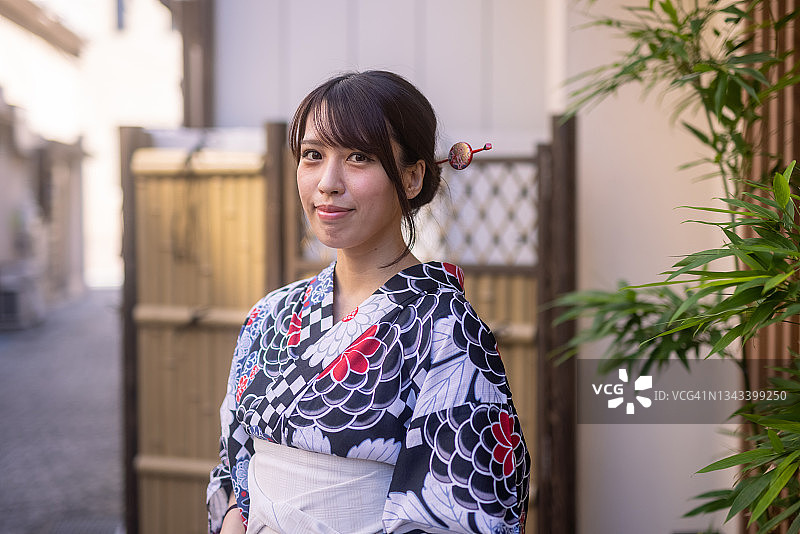 身穿浴衣站在老街上的日本女子肖像图片素材