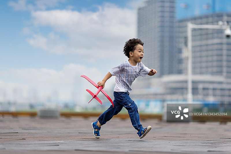 在公园玩模型飞机的小男孩图片素材