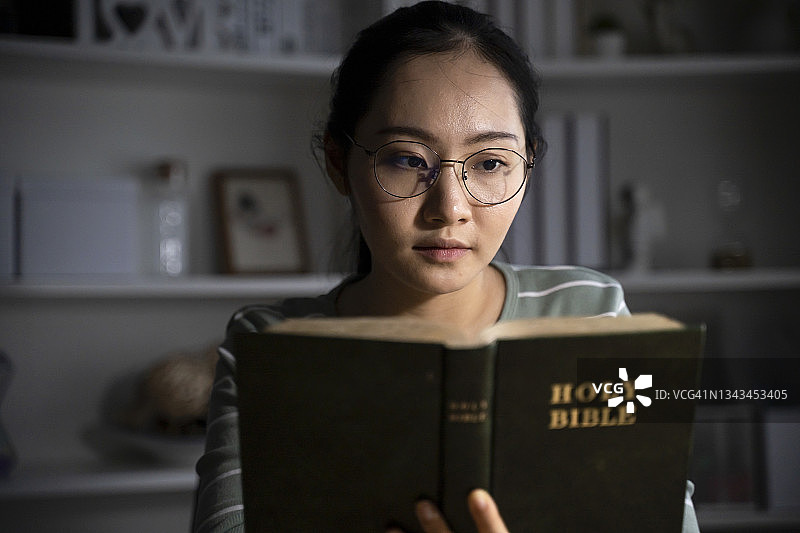 年轻女子在家里读圣经图片素材