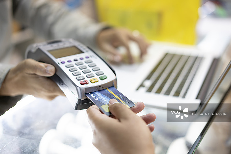 女人在服装店用信用卡购买和支付图片素材