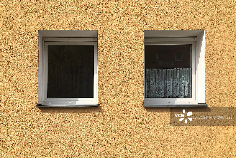 两扇窗户和一个黄色外墙图片素材