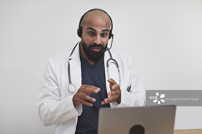 男医生通过笔记本电脑进行视频通话图片素材