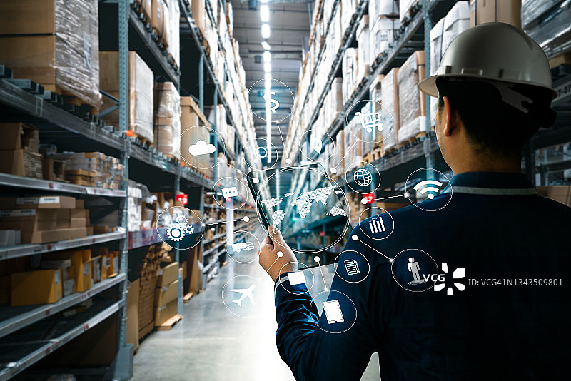 在工厂仓库中手持平板电脑的男人图片素材