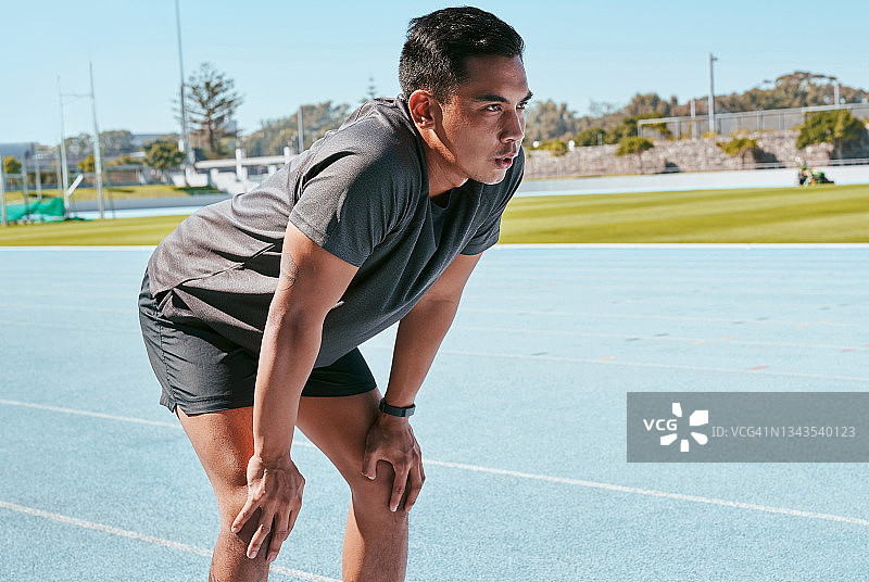 年轻男子在赛道上训练时休息图片素材