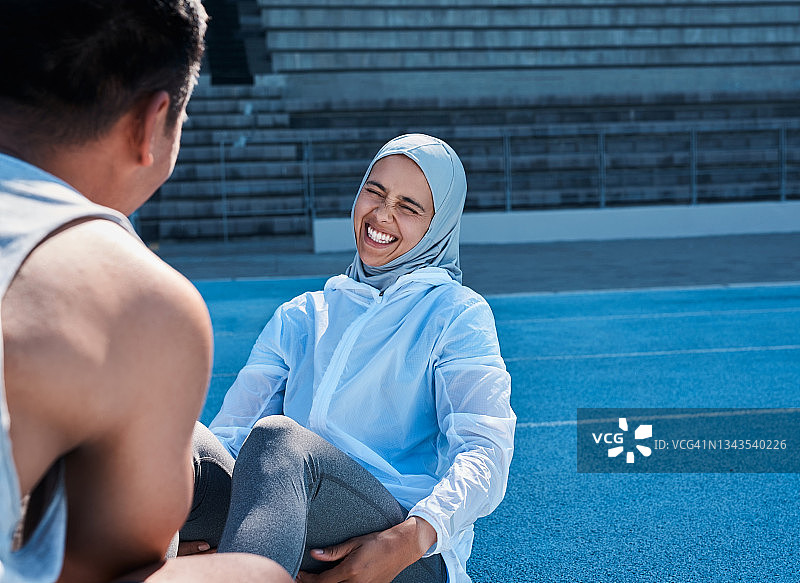 一名女子在赛道上训练时做仰卧起坐图片素材