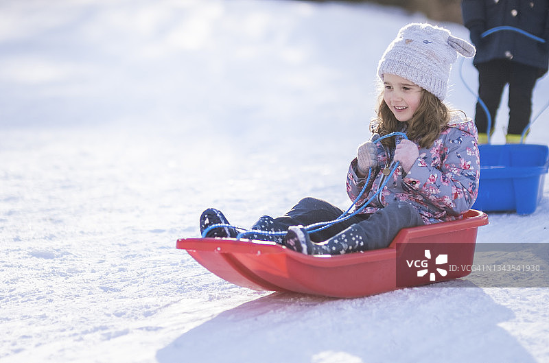 坐在雪橇上的可爱女孩图片素材