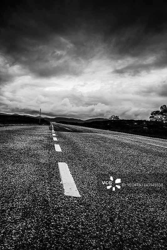 仰视：通往黑暗天空的道路，黑白照片图片素材