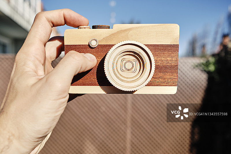 单手握着的木制相机图片素材