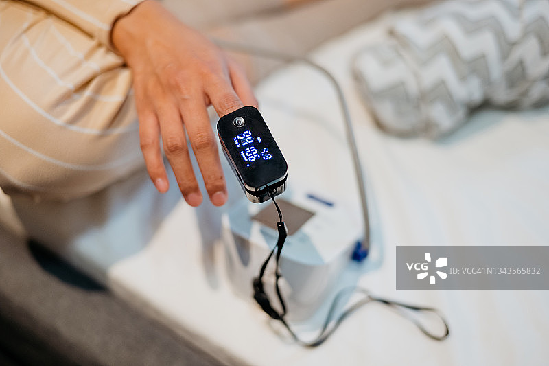 女人用脉搏血氧仪测量血氧水平图片素材