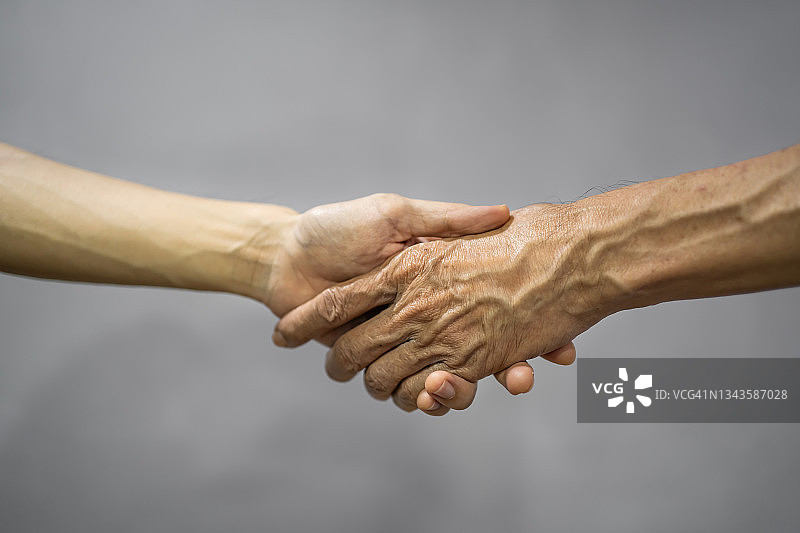年轻和年长的男人手牵着手图片素材