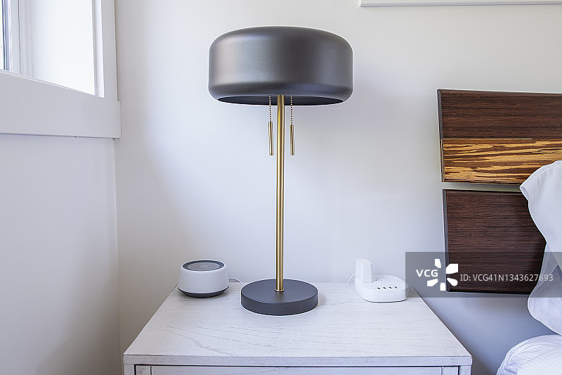 带有灯、智能音箱和充电座的床头柜图片素材