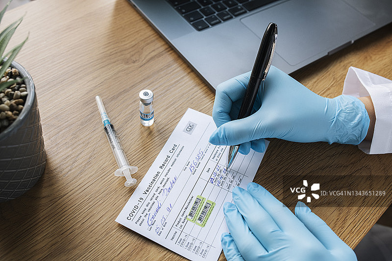 记录卡上填写第二剂新冠疫苗图片素材
