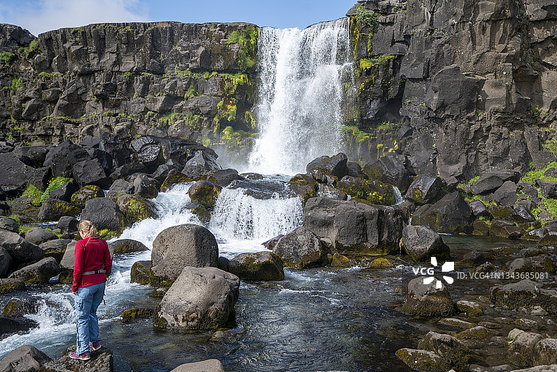 中年妇女欣赏冰岛大西洋中脊奥克萨拉瀑布图片素材
