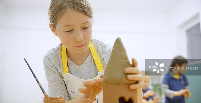 女孩制作粘土鸟舍图片素材