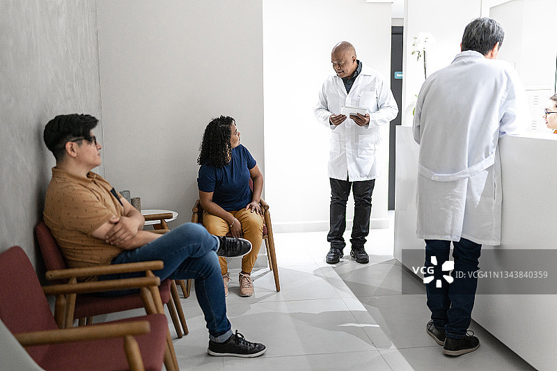 医生在医疗诊所候诊室与病人交谈图片素材