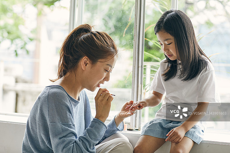 母亲给女儿涂指甲图片素材