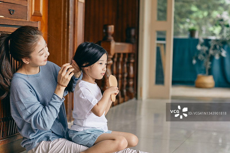 母亲为女儿扎头发图片素材