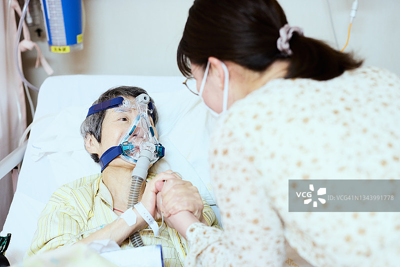 家人鼓励使用吸氧器的母亲图片素材