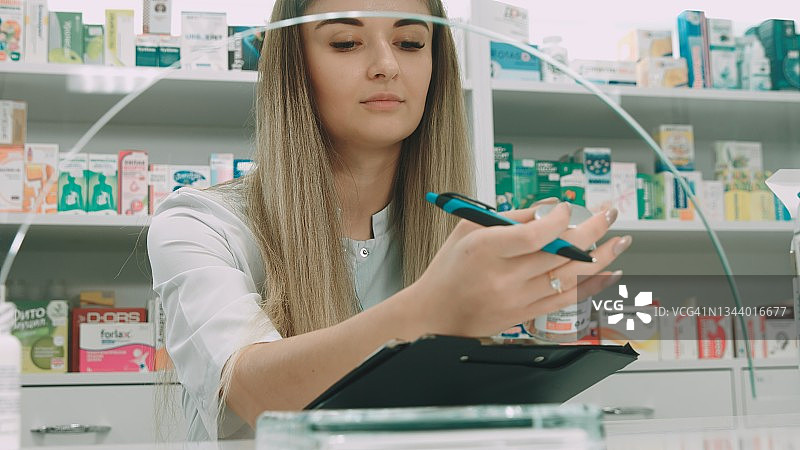 药剂师查看药品成分并记录图片素材