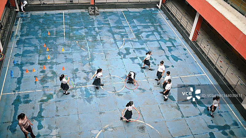 体育课期间在学校操场上玩耍的 uniform 学生图片素材