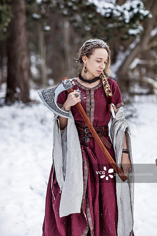 在白雪皑皑的森林里美丽的金色维京女战士公主图片素材